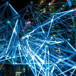Dynamic urban scene showcasing interconnected light trails representing digital communication networks.
